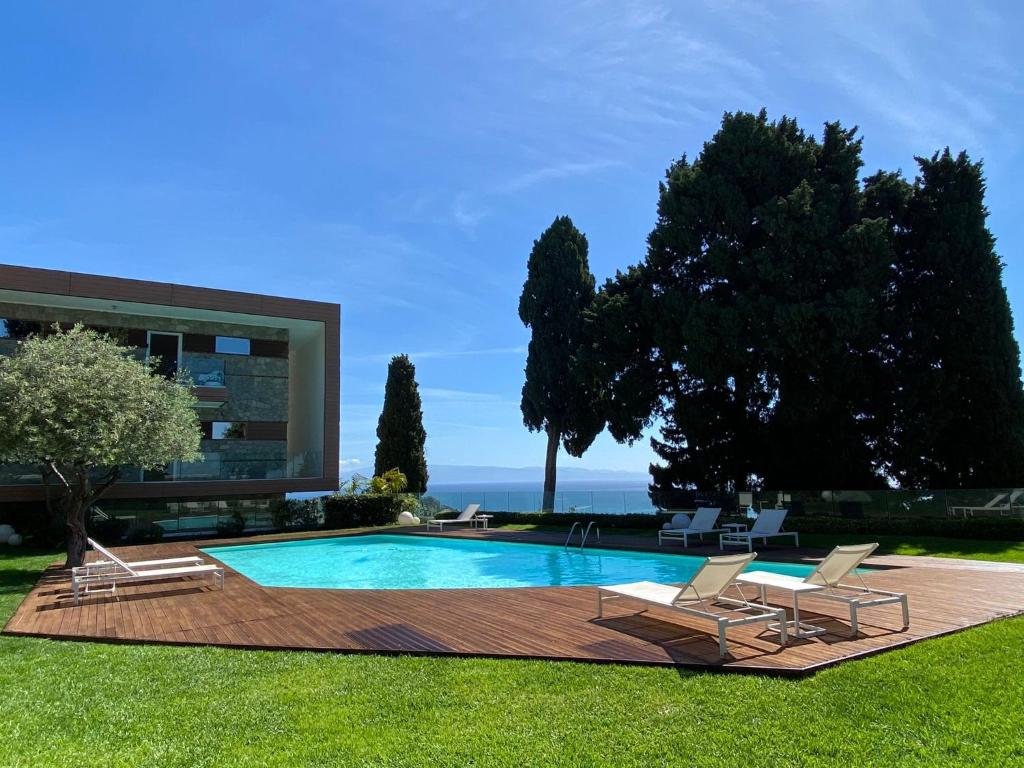 einem Pool mit zwei Liegestühlen und einem Gebäude in der Unterkunft Taormina Suite Mon Repos in Taormina