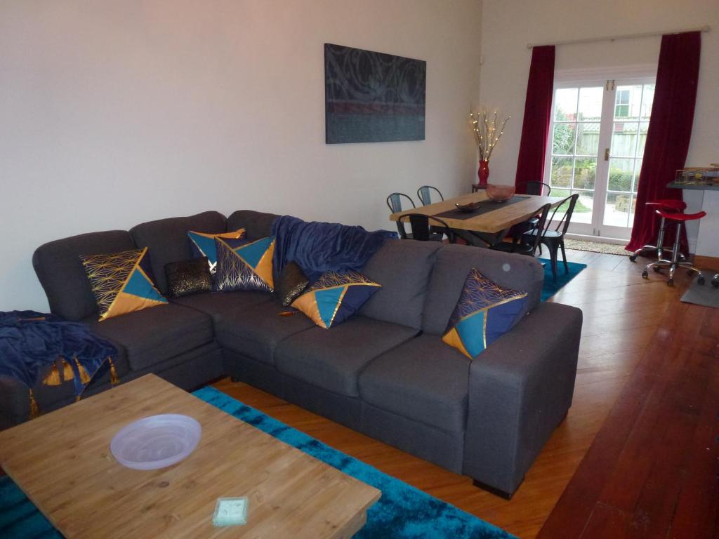 a living room with a couch and a table at Old world charm in town and by the sea in Napier