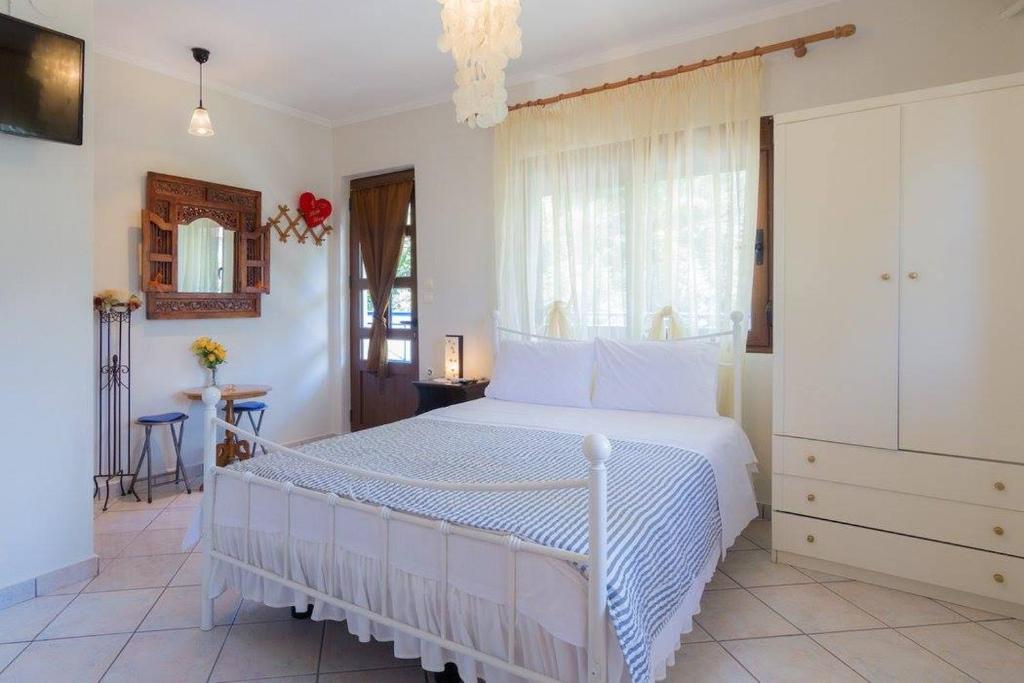 a bedroom with a white bed and a window at Lena Studios in Skala Potamias