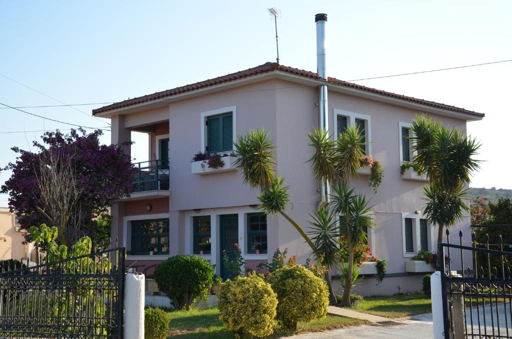 Biały dom z palmami przed nim w obiekcie Rena's House w mieście Kalogria