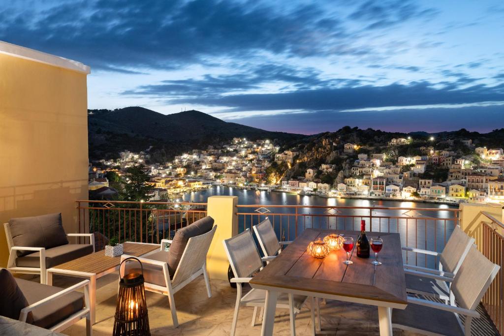 a balcony with a table and chairs and a city at Sea La Vie Villa Symi in Symi