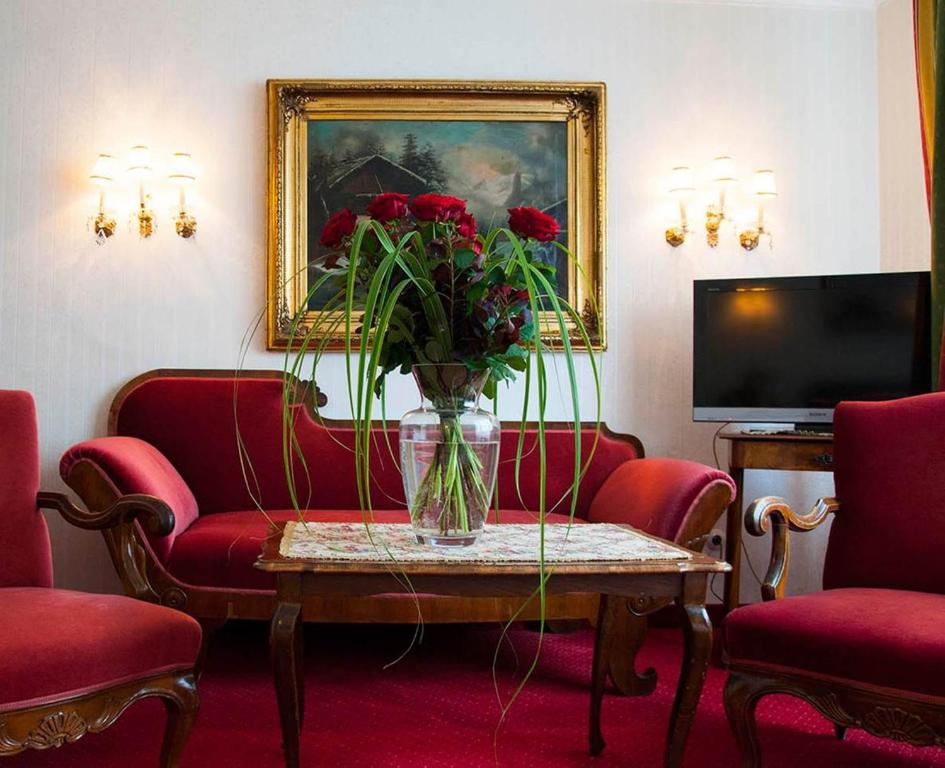 een woonkamer met een vaas met bloemen op een tafel bij Pension Suzanne in Wenen