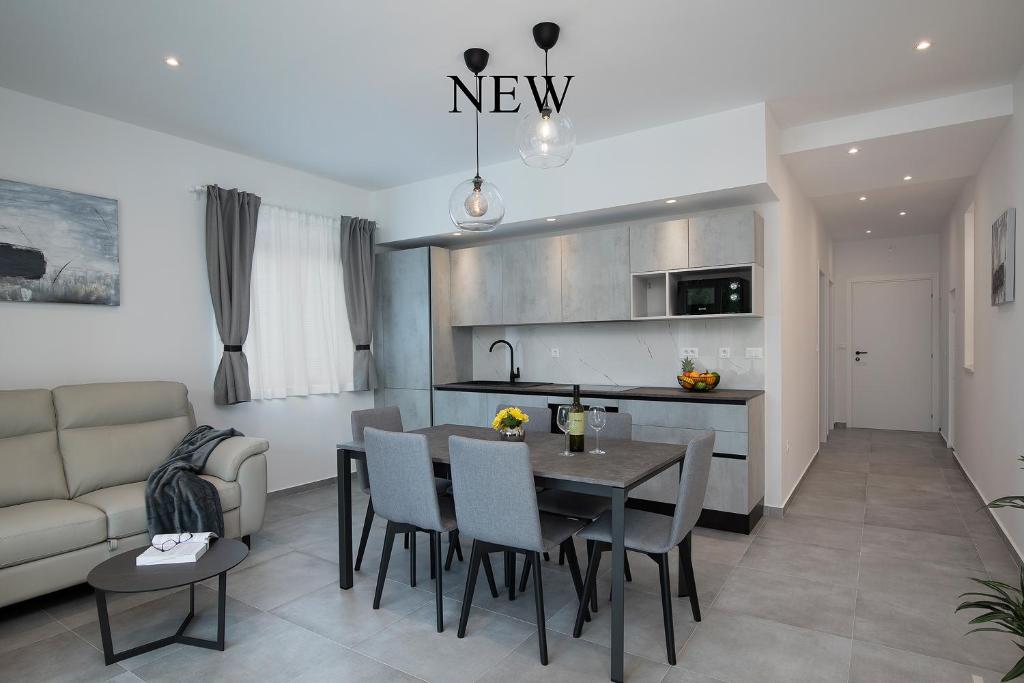 a kitchen and living room with a table and chairs at Apartments Igor in Medulin