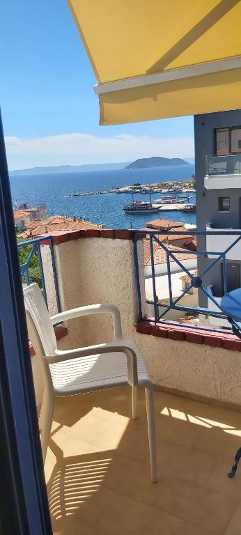 Biały fotel na balkonie z widokiem na ocean w obiekcie Egeon Studios w mieście Neos Marmaras
