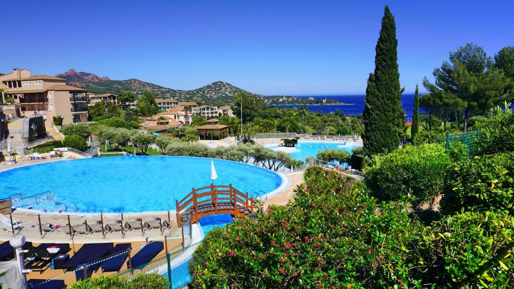 a view of a large swimming pool in a resort at Appartement 174, Vue mer à Cap Esterel By Palmazur in Saint-Raphaël