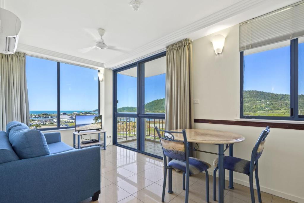 a living room with a couch and a table with chairs at ☆Airliedise☆NO hills☆5min walk 2 Port of Airlie/Ferry terminal☆WiFi☆Netflix in Airlie Beach