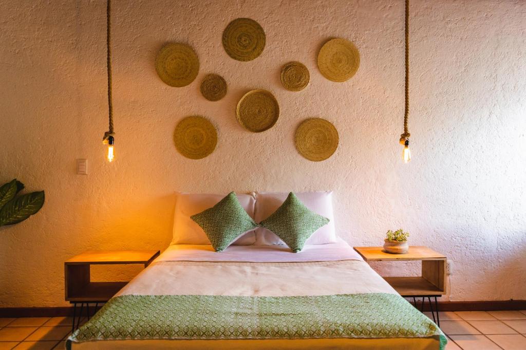 a bedroom with a bed with green pillows at Casa Mayo B&B in Oaxaca City