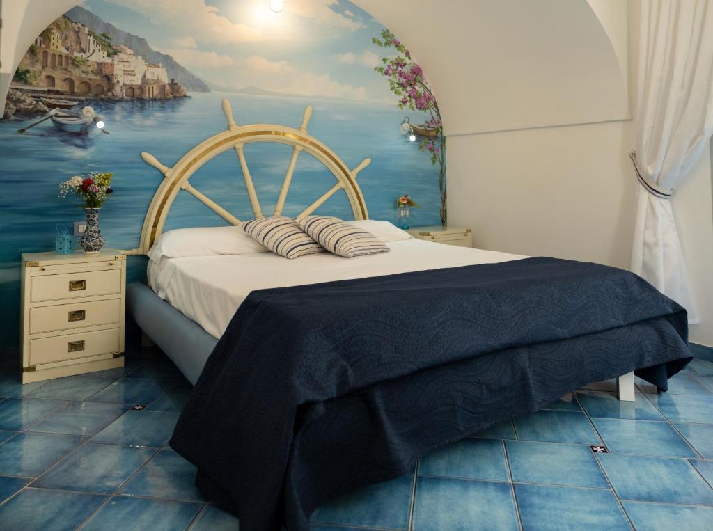 um quarto com uma cama com um quadro na parede em La Rosa dei Venti - Scirocco em Amalfi