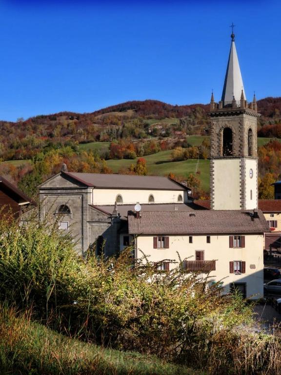 budynek z wieżą i kościołem z wieżą w obiekcie LA CASETTA DELLA NONNA w mieście SantʼAnna Pelago
