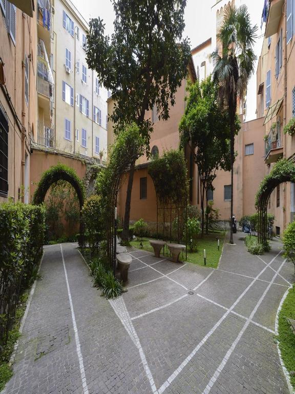 dziedziniec z ławkami, drzewami i budynkami w obiekcie Polinari Rooms San Pietro Roma w Rzymie