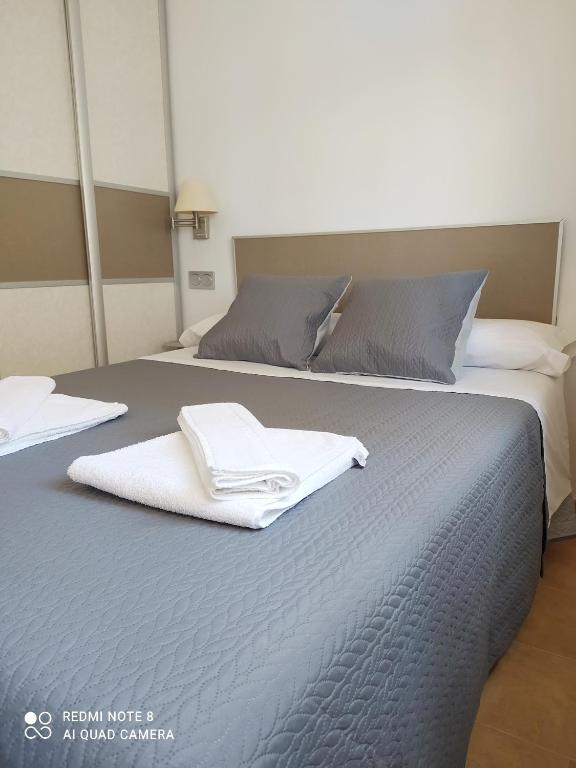 łóżko z dwoma ręcznikami na górze w obiekcie Apartamento playa con vistas al mar w mieście Torre del Mar