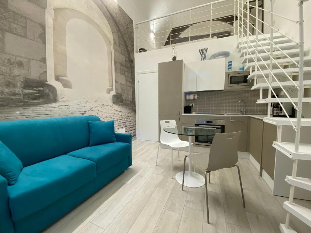 a living room with a blue couch and a kitchen at La Volta in Como