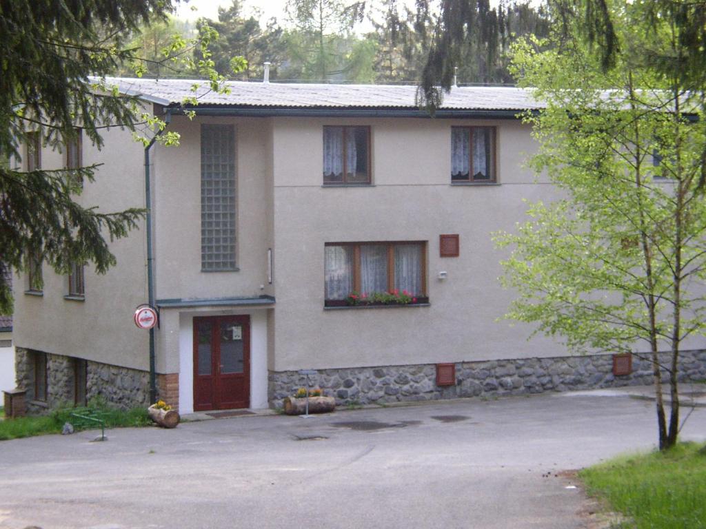 ein weißes Haus mit roter Tür und roten Fenstern in der Unterkunft Chata na Pile in Sedlice