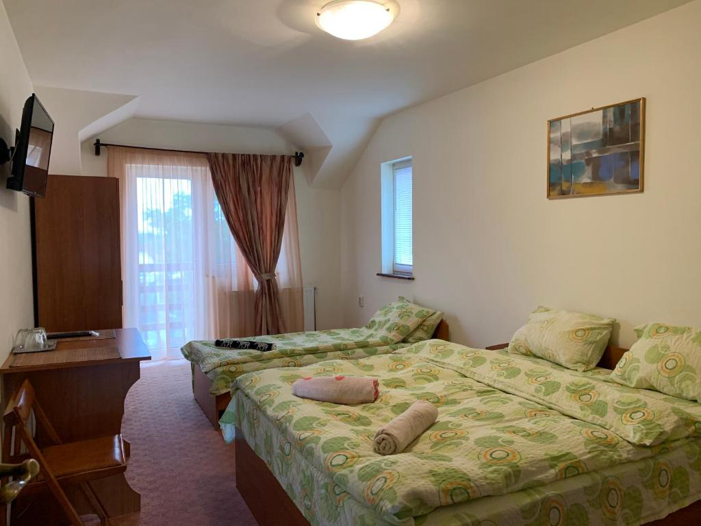 a hotel room with a bed and a couch at Casa Zmeilor in Tăşnad