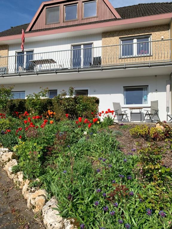 un edificio con un jardín de flores delante de él en Fewo Moselblick, en Traben-Trarbach