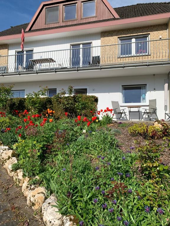 a building with a flower garden in front of it at Fewo Moselblick in Traben-Trarbach