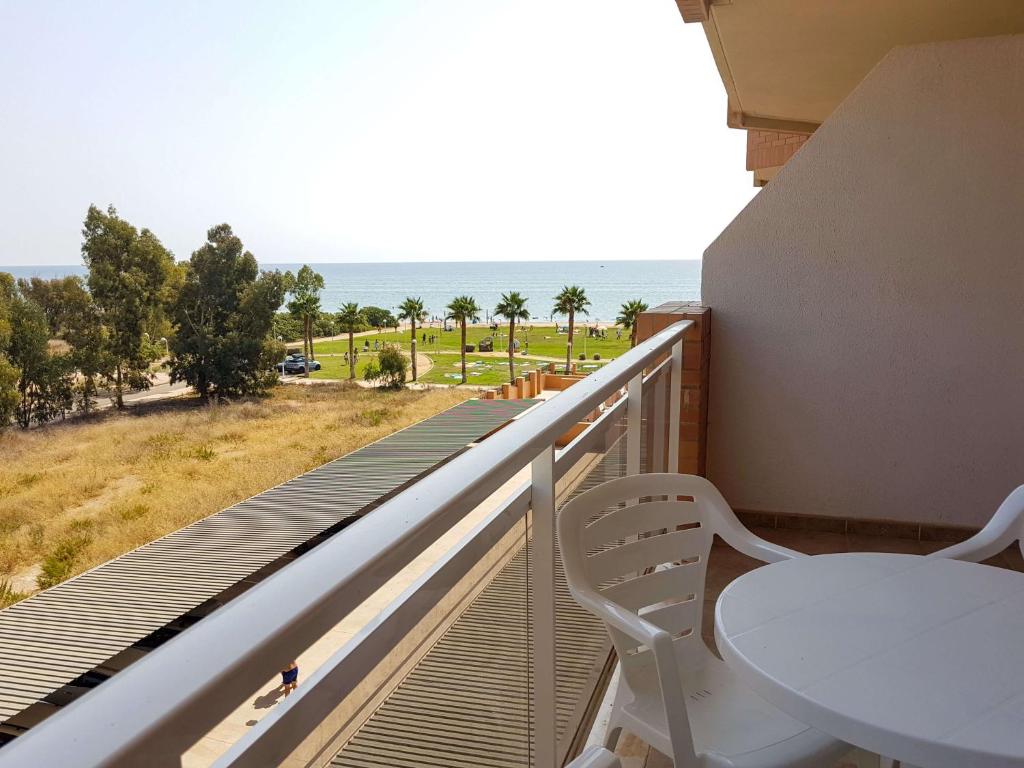 d'un balcon avec une table et une vue sur l'océan. dans l'établissement Apartamento en primera linea, à El Borseral