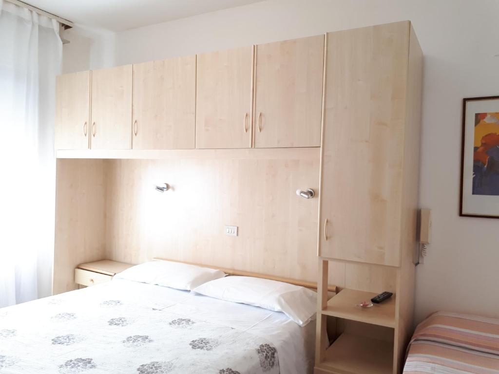 ein kleines Schlafzimmer mit einem Bett und Schränken in der Unterkunft Hotel Villa Dina in Lido di Jesolo