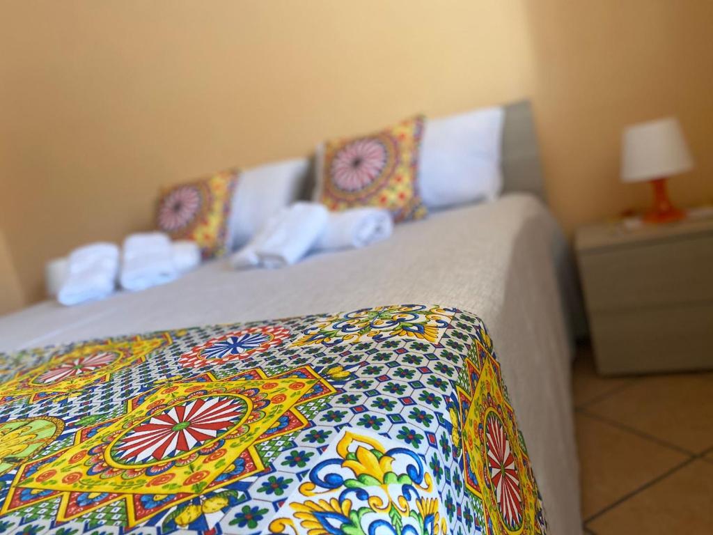 1 dormitorio con 1 cama con una manta colorida en Le Maioliche Gialle Sferracavallo, en Sferracavallo