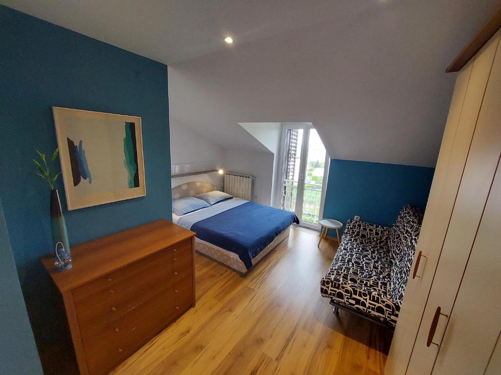a bedroom with blue walls and a bed and a dresser at Apartma Marina in Piran