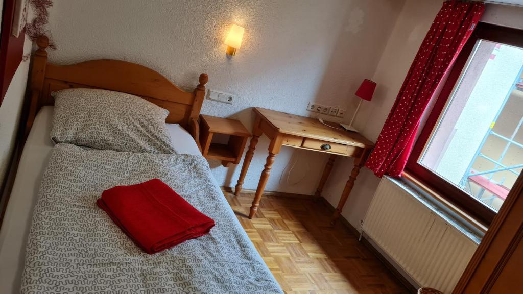a bedroom with a bed with a red pillow on it at Hotel Kartäuser Hof Mainz Bodenheim in Bodenheim