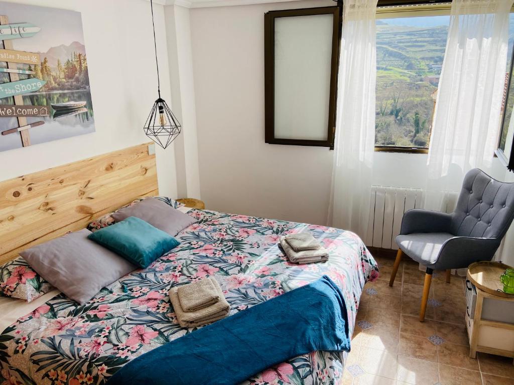 1 dormitorio con 1 cama, 1 silla y 1 ventana en Casa El calado, en Viguera