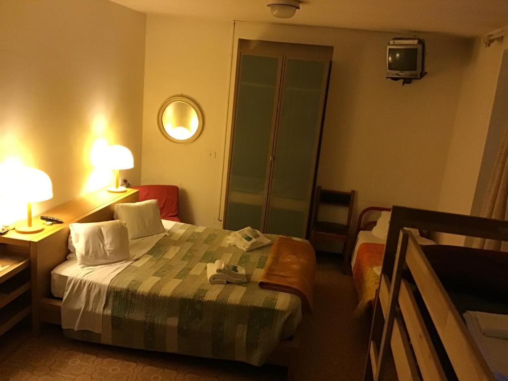 a hotel room with a bed and a mirror at OSTELLO MIRABEAU in Bellagio