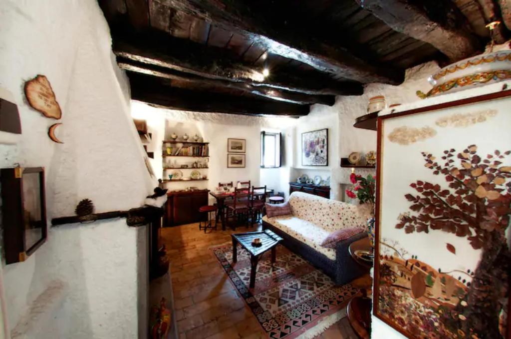 uma sala de estar com um sofá e uma mesa em Casa Graziella al Borgo em Mazzano Romano