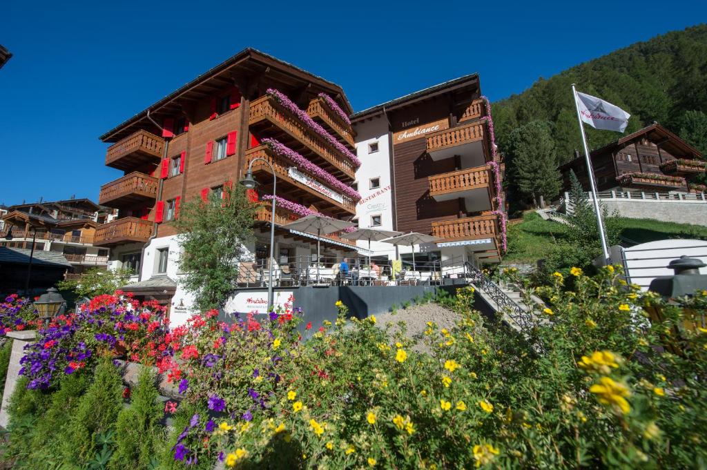 grupa budynków z kwiatami przed nimi w obiekcie Hotel Ambiance Superior w mieście Zermatt