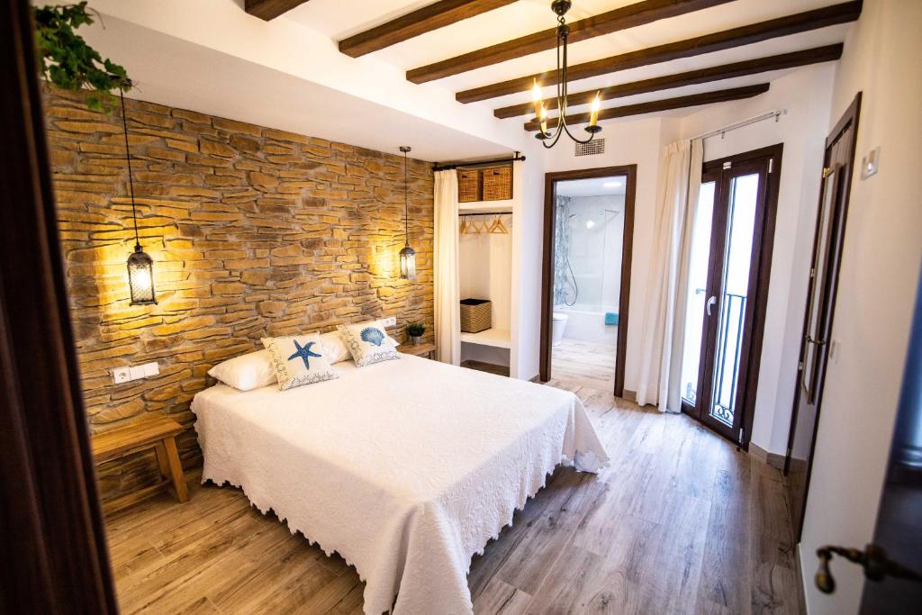 ein Schlafzimmer mit einem Bett und einer Steinwand in der Unterkunft Maremar Suites in Benidorm