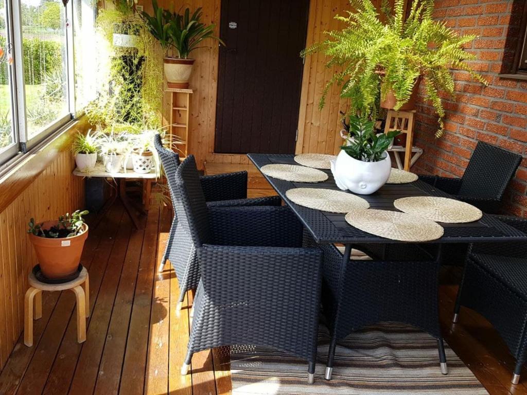 un patio con mesa, sillas y macetas en Lucia and Roland house en Falkenberg
