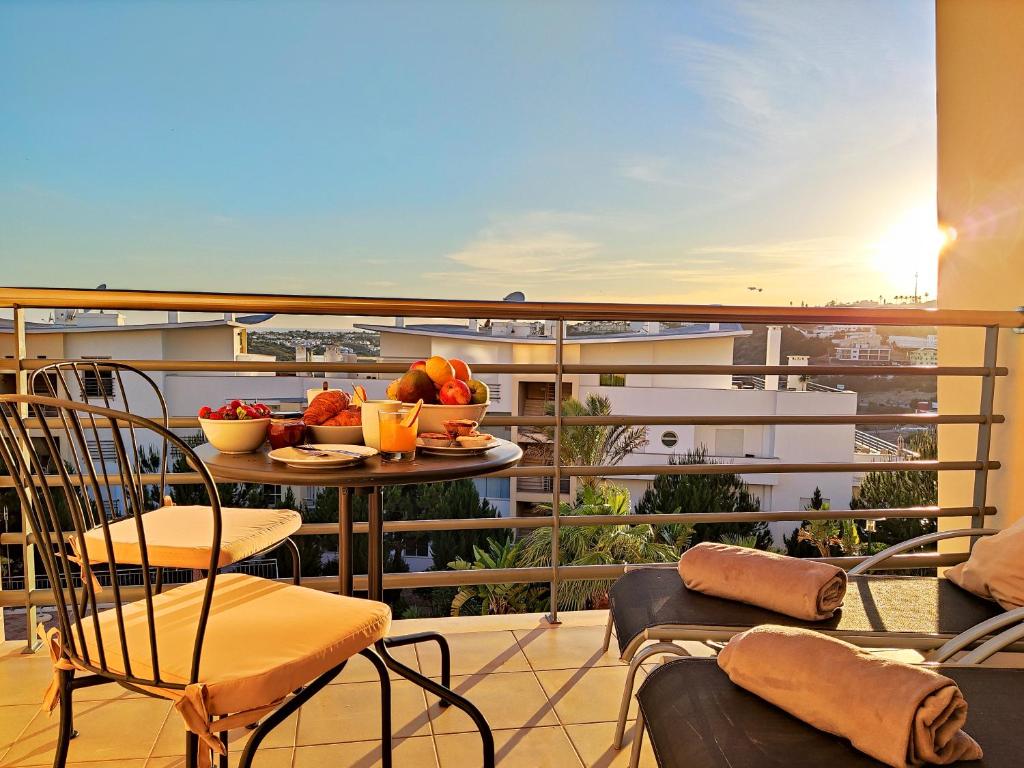 balcone con tavolo e frutta di Modern Ocean, Garden & Pool view Condo by BeCherish ad Albufeira
