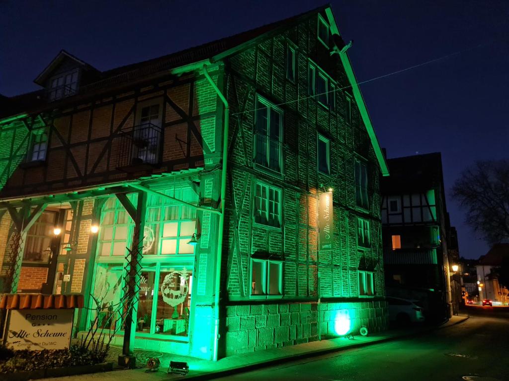a green light shines on a building at night at Pension Alte Scheune in Melsungen
