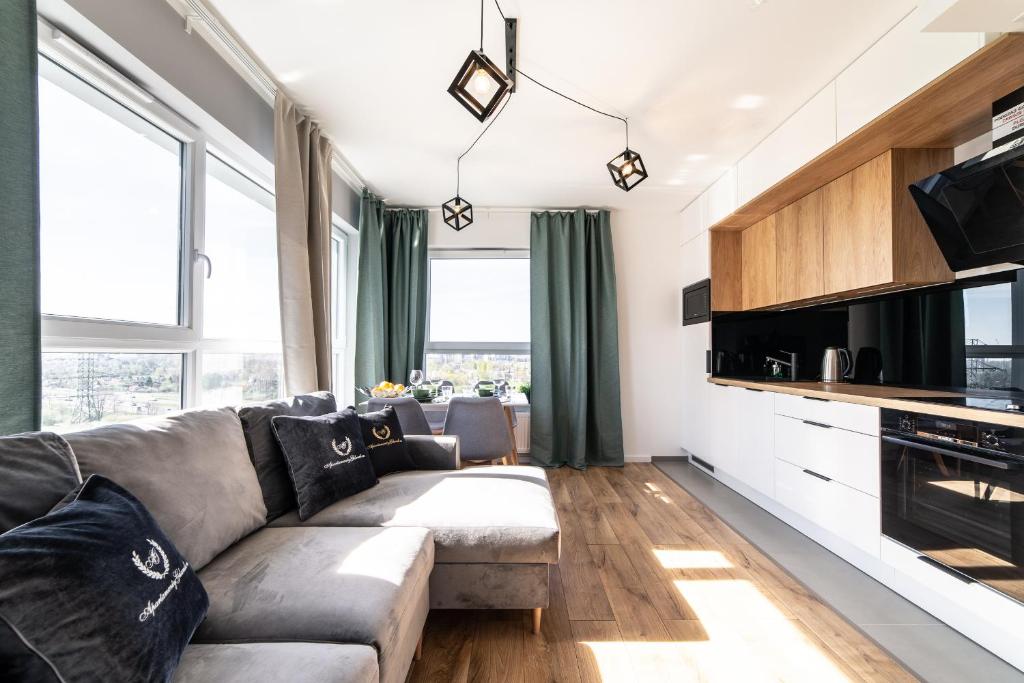 a living room with a couch and some windows at Apartamenty Gdansk EU - Baltica Towers 223 in Gdańsk