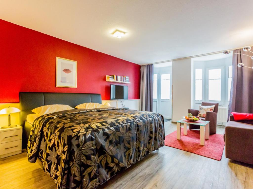 una camera con letto e parete rossa di Residenz Meeresbrandung a Cuxhaven