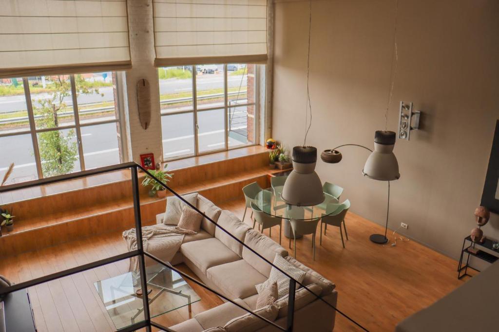 - un salon avec un canapé et une table en verre dans l'établissement luxurious loft Oudenaarde in The Flemish Ardennes, à Audenarde