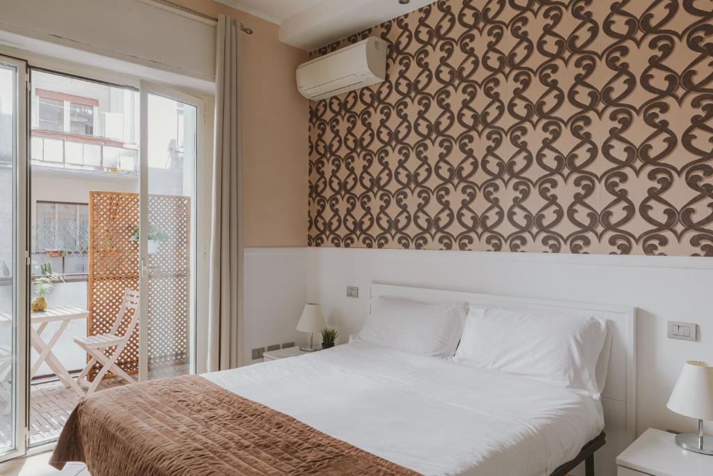 1 dormitorio con 1 cama y una pared con un patrón en Residenza Il Duca, en Roma