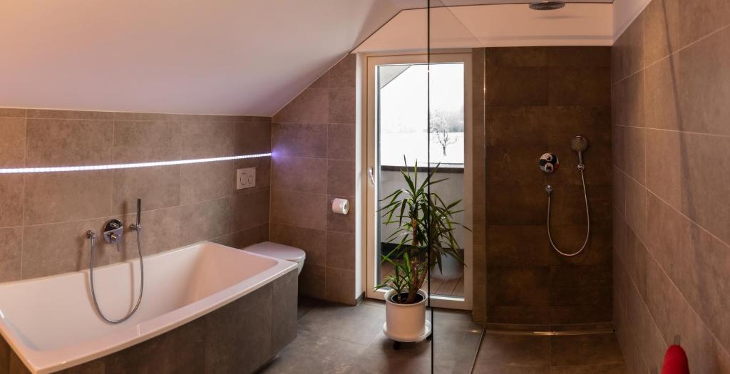 ein Badezimmer mit einer Badewanne und einer Pflanze darin in der Unterkunft Bodenseedomizil in Lochau