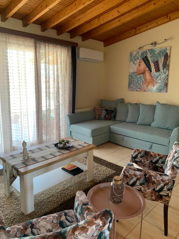a living room with a couch and a table at Aquarella Apartment in Chrysoupolis