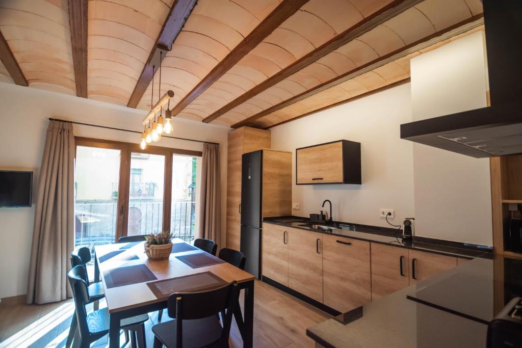 eine Küche und ein Esszimmer mit einem Tisch und Stühlen in der Unterkunft Cal Negret Rural Apartments in Alós de Balaguer