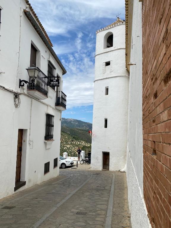an alleyway between two white buildings with a car at Casa Rural Azahara in Zahara de la Sierra