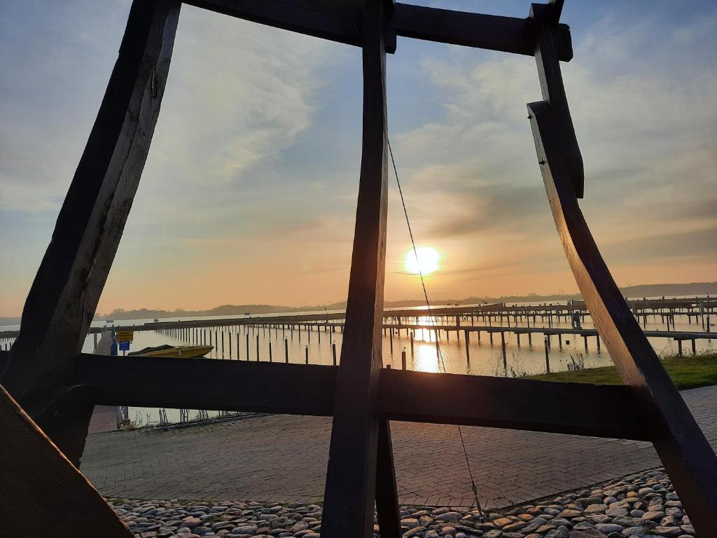 een uitzicht op een pier bij zonsondergang vanaf een hek bij Wormshöft 16 in Hasselberg