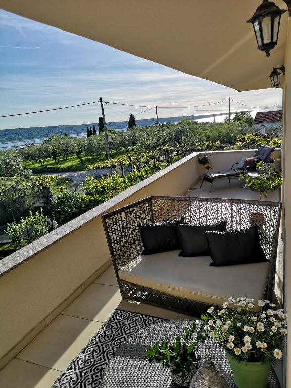 a balcony with a bench and a view of the ocean at Apartma Isabella in Sečovlje