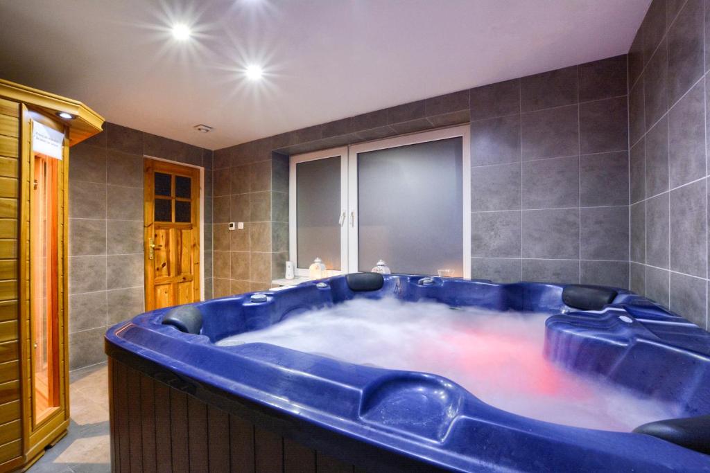 eine große blaue Badewanne im Bad in der Unterkunft 4 Pory Roku in Karpacz