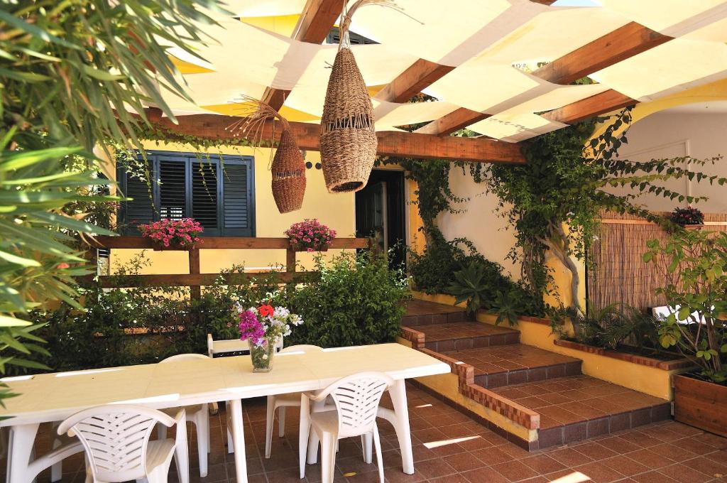 a patio with a table and chairs and plants at Casa Mare Holiday Pozzallo in Pozzallo