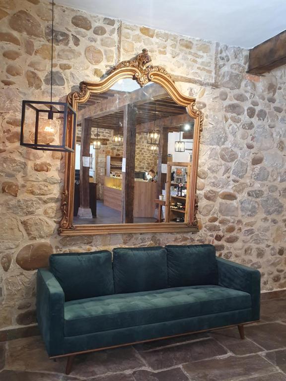 a green couch in a room with a mirror at Ermita 1883 in Puente San Miguel