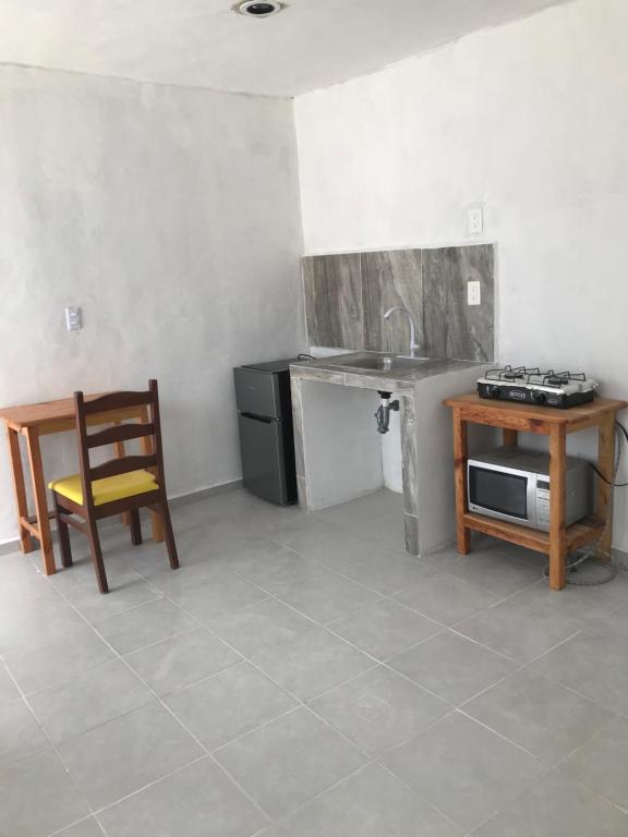 Departamento sencillo en CAMPECHE EX HACIENDA KALA في كامبيش: مطبخ مع حوض وطاولة وكرسي