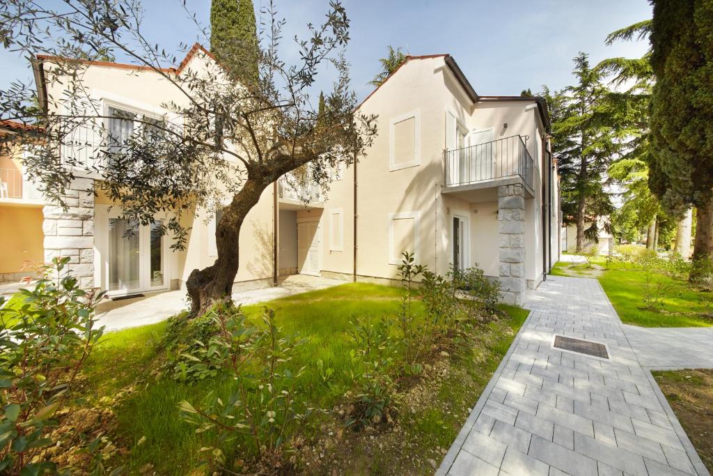 - une vue sur l'extérieur d'une maison blanche avec une passerelle dans l'établissement Olive Family Suites - Hotel & Resort Adria Ankaran, à Ankaran