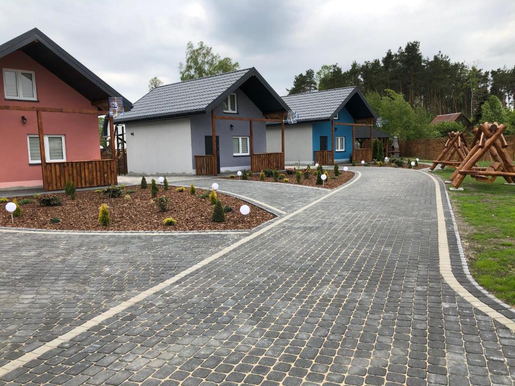 una entrada de adoquines frente a las casas en Kokosowy Zakątek en Szczekarzewo