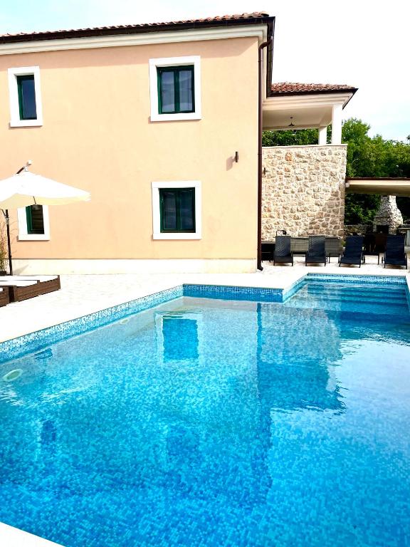 a swimming pool in front of a villa at Villa Muraj-Kornić, Krk in Kornić